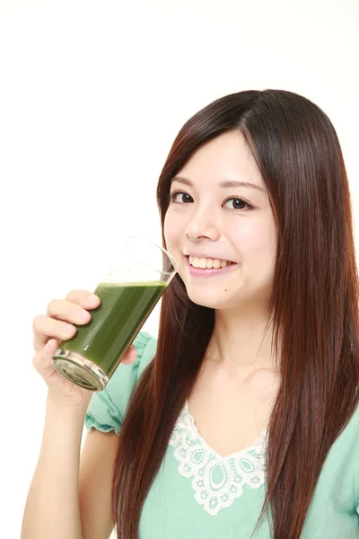 Mulher japonesa nova com suco vegetal verde — Fotografia de Stock