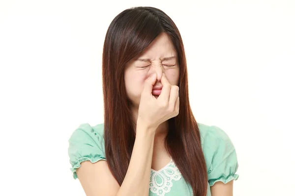 日本女人抱着她的鼻子因为难闻的气味 — 图库照片