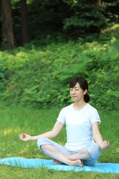 Японская женщина снаружи занимается медитацией — стоковое фото