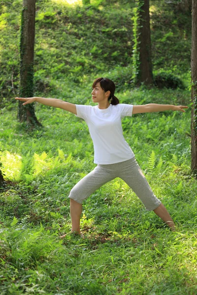 Japonská žena venku dělá jógu warrior Ii představují — Stock fotografie