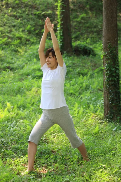 Ben poz yoga savaşçı yapıyor dışında Japon kadın — Stok fotoğraf
