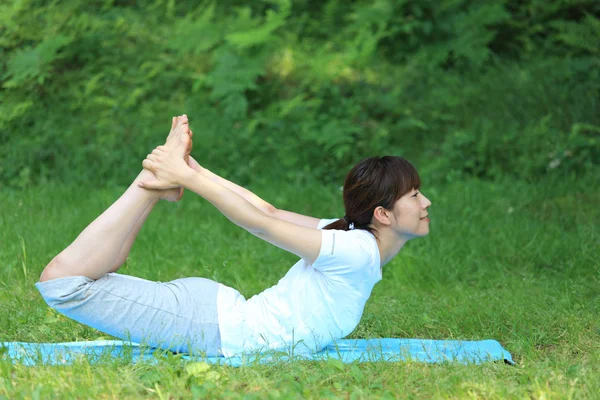 Japonês mulher fora fazendo ioga sapo pose — Fotografia de Stock