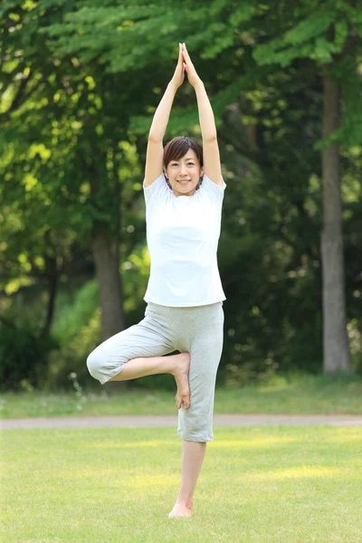 Japonská žena mimo strom pózuje jóga — Stock fotografie