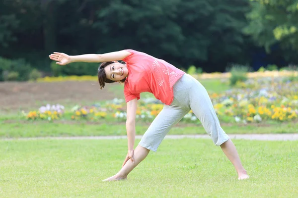 Japonês mulher fora fazendo ioga triângulo pose — Fotografia de Stock