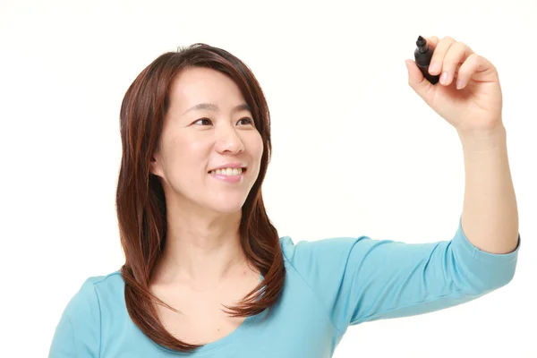 Middelste leeftijd Japanse vrouw tekenen in de lucht — Stockfoto