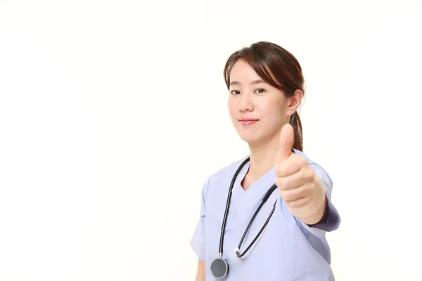 Japonês feminino médico mostrando polegares até gesto — Fotografia de Stock