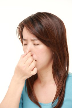 Kötü bir koku yüzünden burnunu tutan Japon kadın