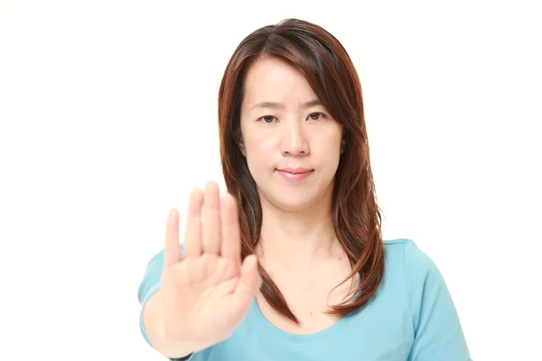 Mediana edad japonesa mujer haciendo stop gesture —  Fotos de Stock