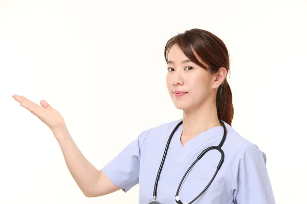 Japonesa mujer médico presentando y mostrando algo — Foto de Stock