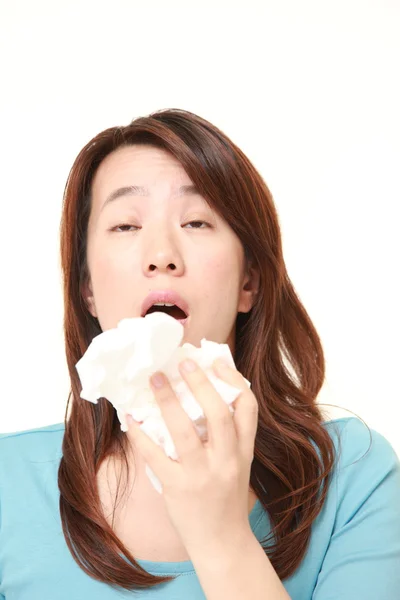 Middle aged woman with an allergy sneezing into tissue — Stock Photo, Image