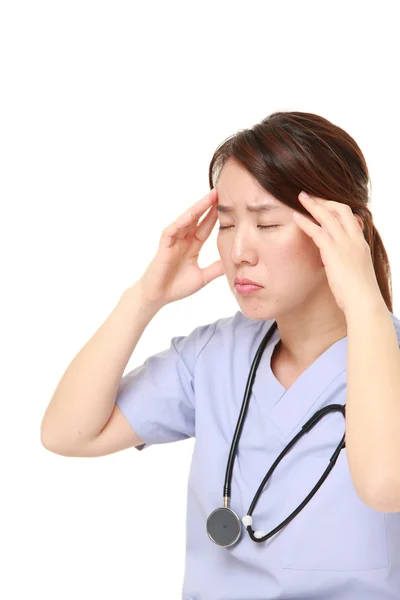 Japonesa médico femenino sufre de dolor de cabeza —  Fotos de Stock