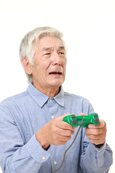 Senior Japanese man losing playing video game — Stock Photo, Image