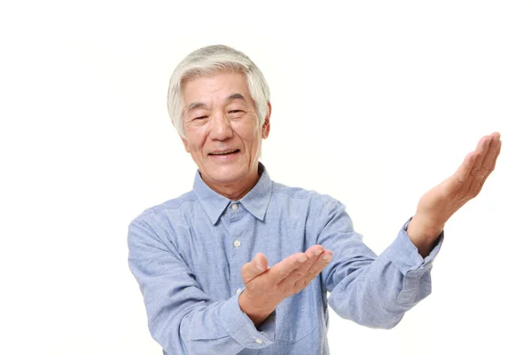 Sênior japonês homem apresentando e mostrando algo — Fotografia de Stock