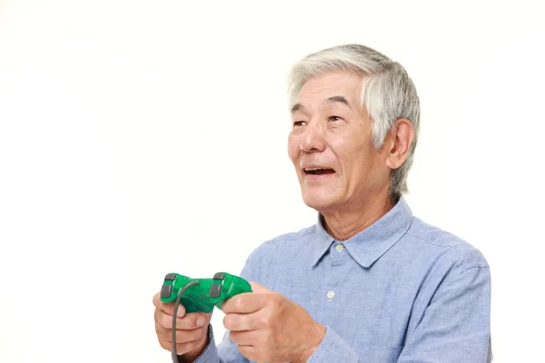 Старший японською людини, насолоджуючись відеоігри — стокове фото