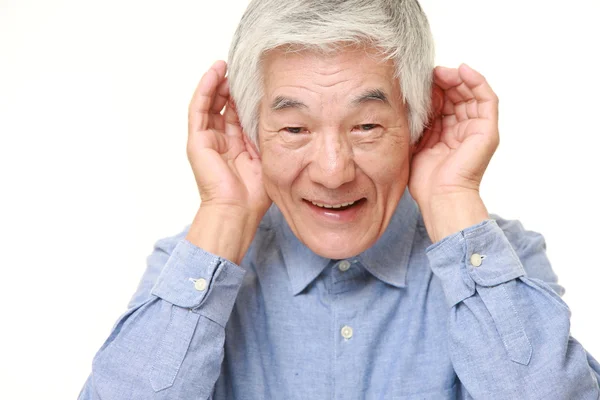 Ledande japanska man med handen bakom örat lyssnar noga — Stockfoto