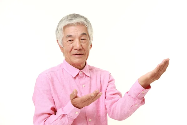 Sênior japonês homem apresentando e mostrando algo — Fotografia de Stock