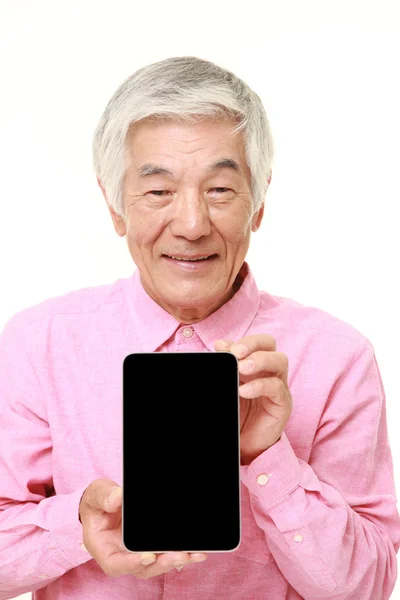 Старший японский мужчина держит планшетный компьютер — стоковое фото