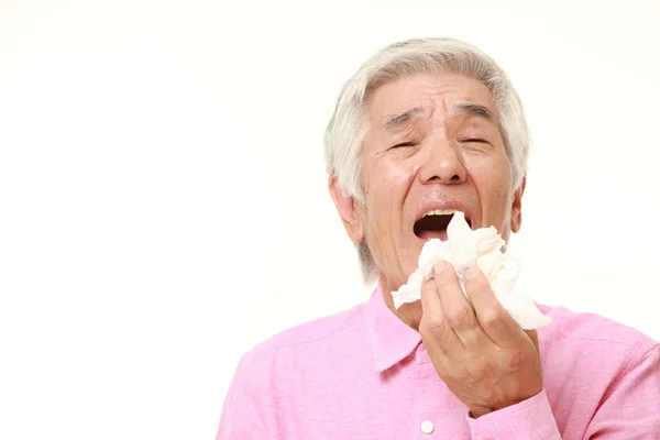 Senior Japanse man met een allergie niezen in weefsel — Stockfoto