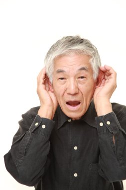 yakından dinlerken kulak arkasında el ile üst düzey Japon adam