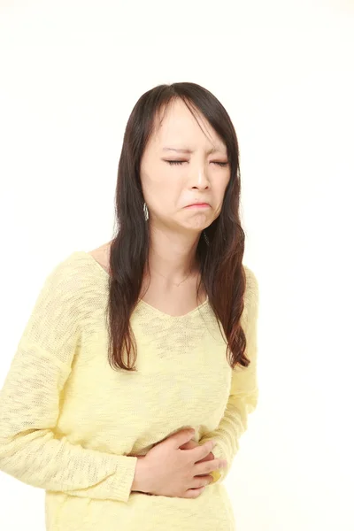 Young Japanese woman suffers from stomachache — Stock Photo, Image