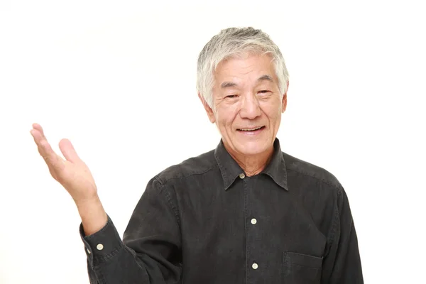 Senior pria Jepang menyajikan dan menunjukkan sesuatu — Stok Foto
