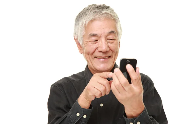 Senior mand med en smart telefon - Stock-foto