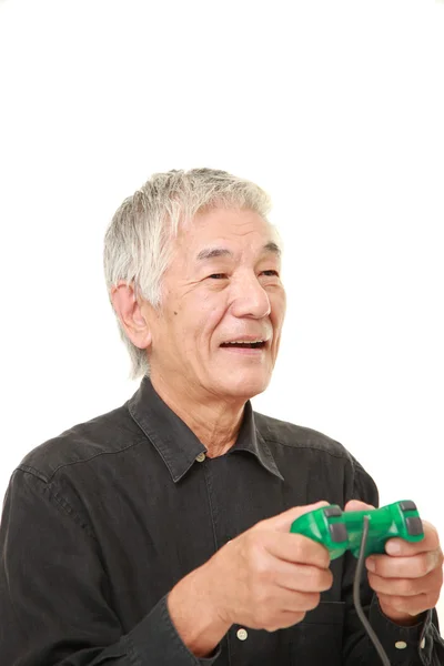 Senior japonés hombre disfrutando de un video juego —  Fotos de Stock