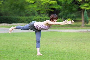 Yoga savaşçı III poz yaparken dışında Japon kadın