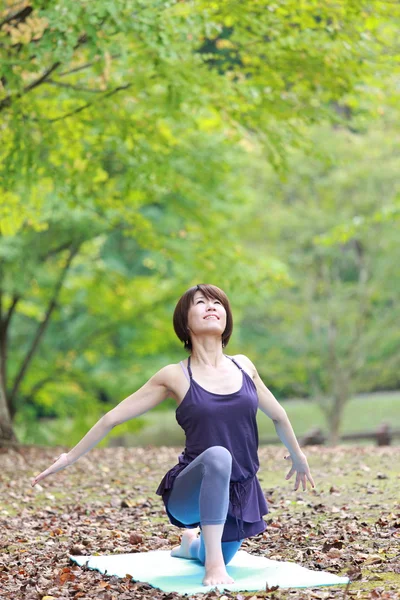 Portrait of Japanese woman outside doing yoga — Stock Photo, Image