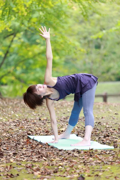 Japanese woman outside doing yoga — Stock Photo, Image