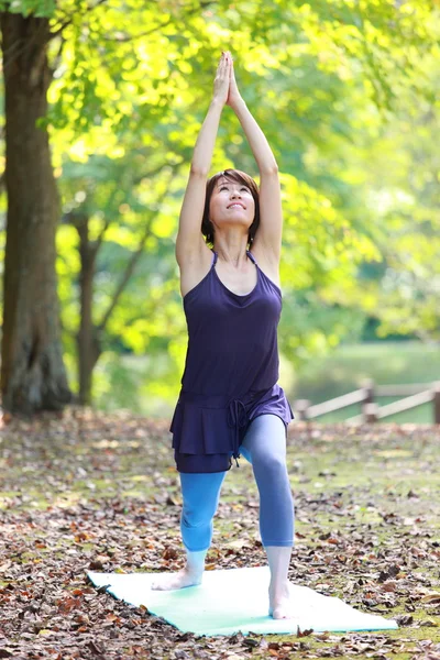 Japonês mulher lá fora fazendo ioga guerreiro eu posar — Fotografia de Stock