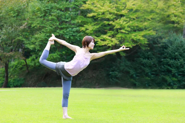 Save Download Preview Japanese woman outside doing yoga Lord of the Dance Pose — Stock Photo, Image
