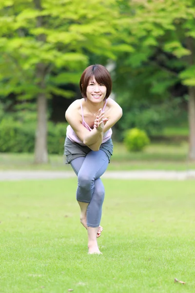 Japonesa mujer afuera haciendo yoga águila pose —  Fotos de Stock