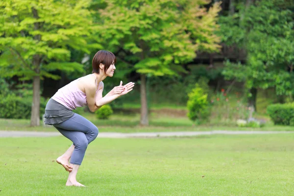 Japonesa mujer afuera haciendo yoga águila pose — Foto de Stock
