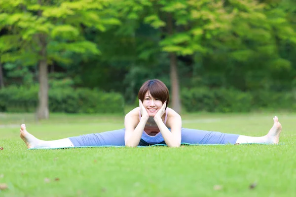 Portrait of Japanese woman outside doing stretches exercise — Stock Photo, Image