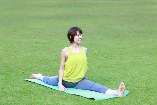 Japansk kvinna utanför gör yoga Monkey utgör — Stockfoto
