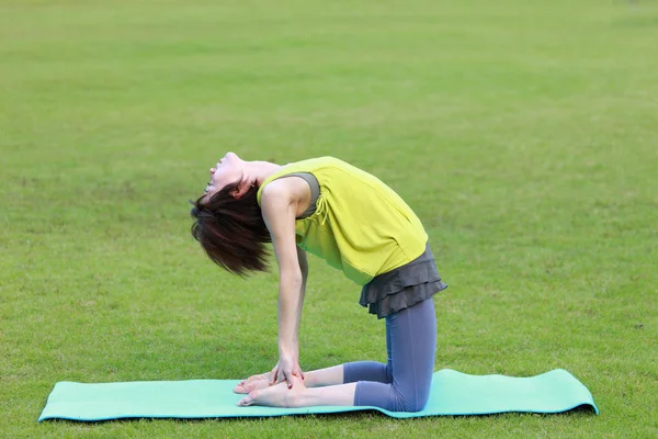 Japanese woman outside doing yoga Camel Pose — Stock Photo, Image