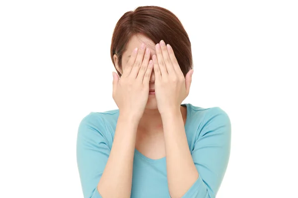 Young Japanese woman covering her face with hands — Stock Photo, Image