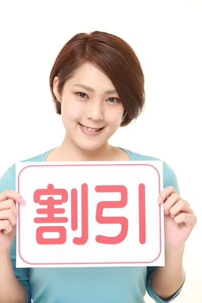 Vrouw met een message board met het zinsdeel korting in Kanji — Stockfoto
