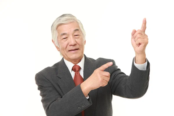 Senior japanischer Geschäftsmann präsentiert und zeigt etwas — Stockfoto