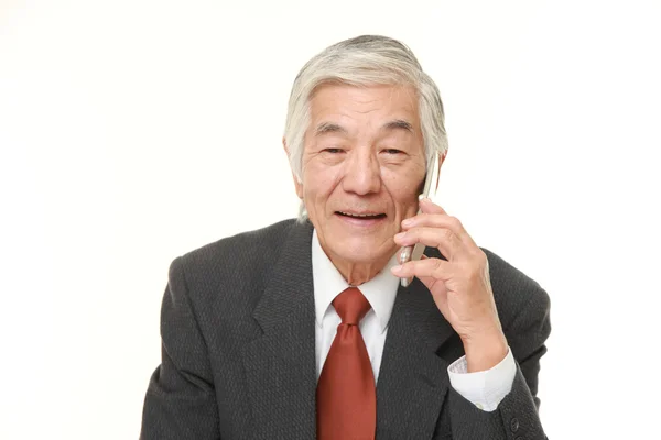Старший бизнесмен беседует с классическим мобильным телефоном — стоковое фото