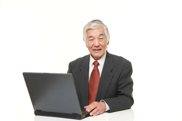 Старший японский бизнесмен, использующий ноутбук — стоковое фото