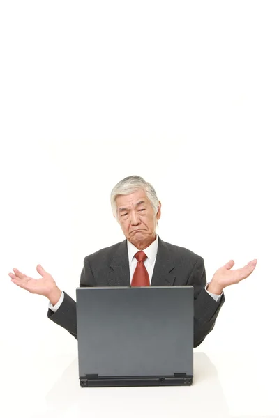 Senior Japanese businessman using computer looking confused — Stock Photo, Image