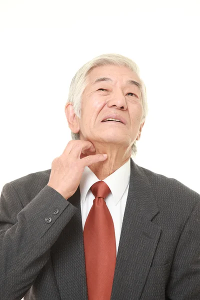 Senior japanischer Geschäftsmann kratzt sich am Hals — Stockfoto