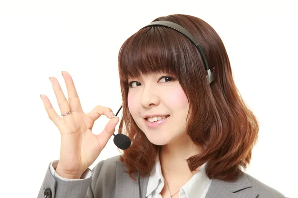 Young Japanese businesswoman of call center with head sets showing perfect sign — Stock Photo, Image