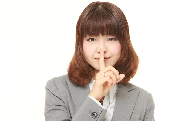 Jeune femme d'affaires japonaise qui fait des gestes de silence — Photo