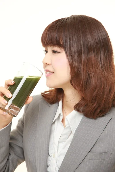 Japanese businesswoman with green vegetable juice — Stock Photo, Image