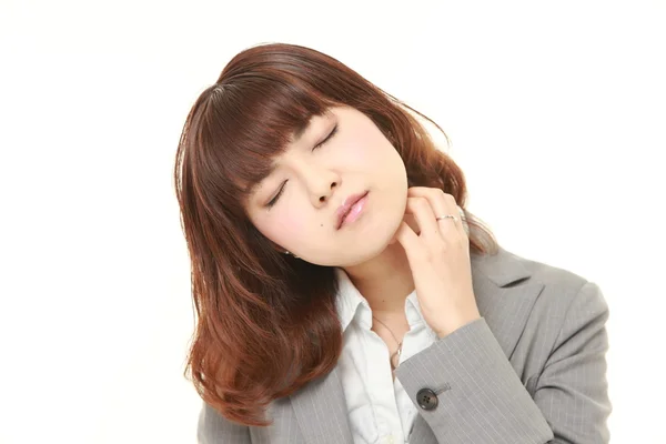 Японская деловая женщина чешет шею — стоковое фото