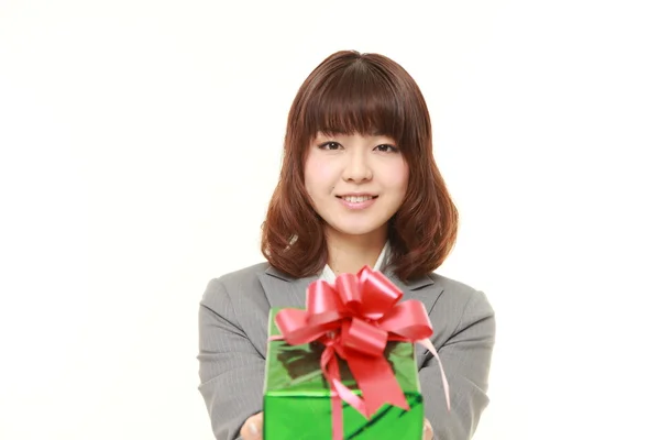 Joven mujer de negocios japonesa ofreciendo un regalo —  Fotos de Stock