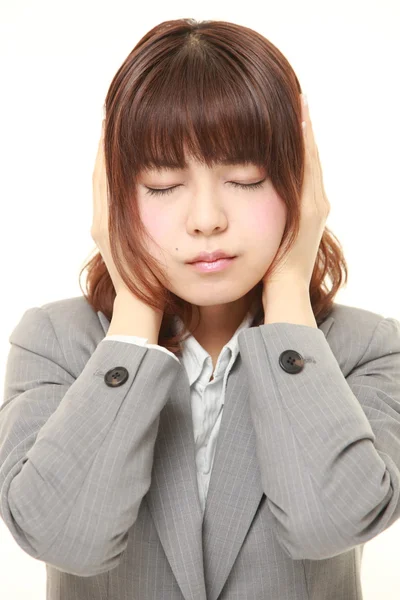 Jovem empresária japonesa sofre de barulho — Fotografia de Stock